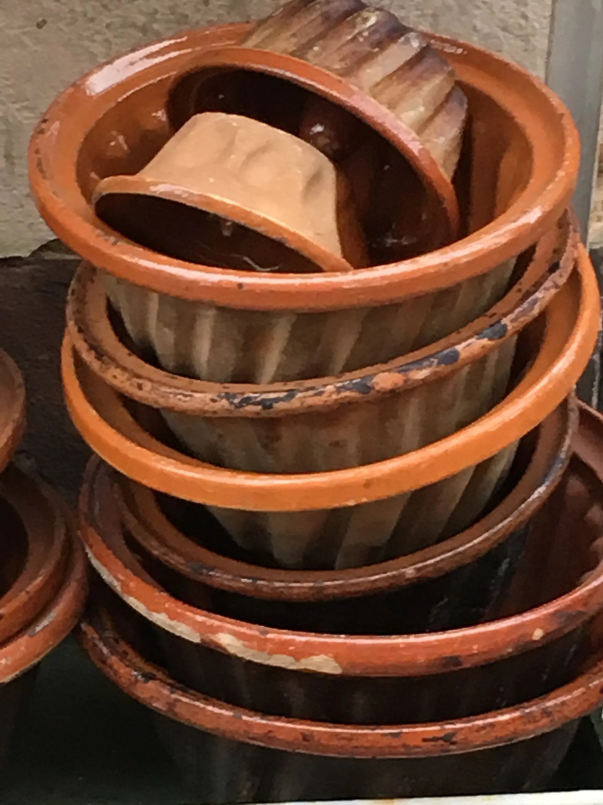 Moules à kouglof traditionnels en terre vernissée accrochés à une façade alsacienne