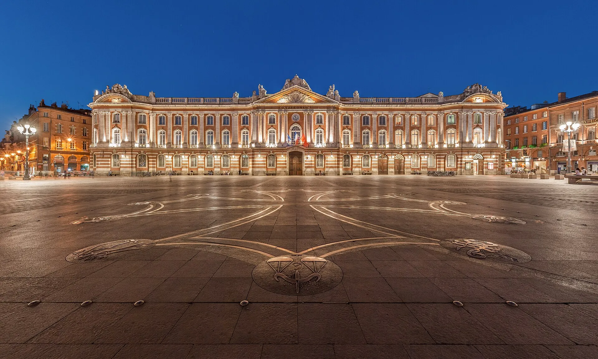 La façade néoclassique du Capitole de Toulouse et sa place pavée, sous un ciel dégagé